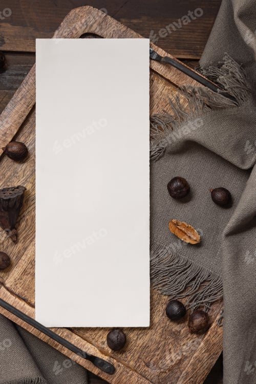 Preview: Vertical card on wooden tray near brown decor and grey linen cloth top view, boho mockup