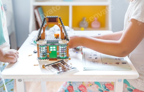 Preview: Girls, sisters play kids constructor, build house Lego Harry Potter from bricks, blocks by assembly
