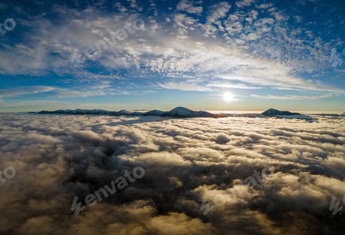 Preview: Aerial view of vibrant sunrise over white dense fog with distant dark Carpathian mountains