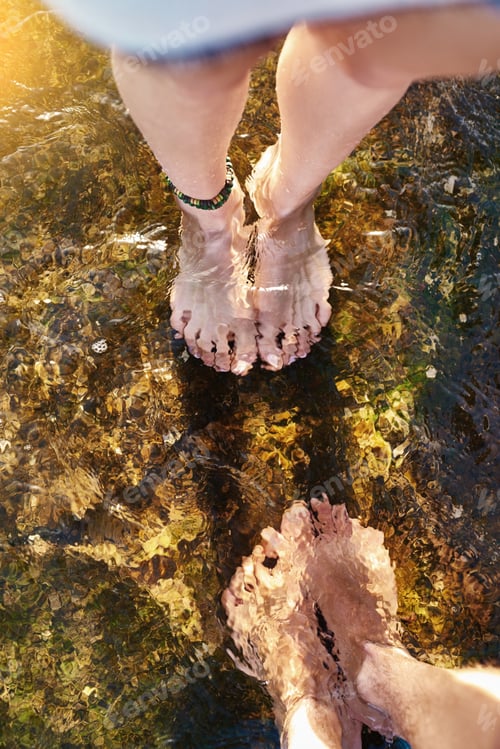 Preview: Go with the flow. Cropped shot of a couple standing in the cool waters of a stream.