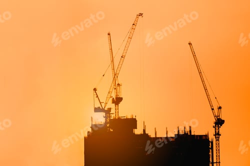 Preview: Silhouette of building construction site including several cranes working on a building complex.