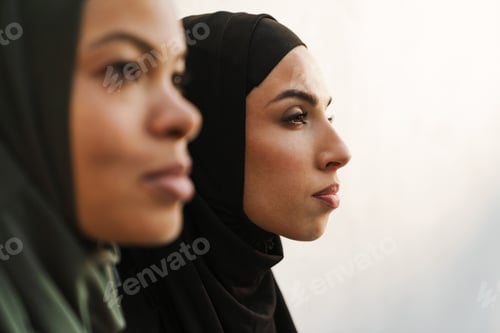 Preview: Multiracial muslim women posing and looking asid outdoors