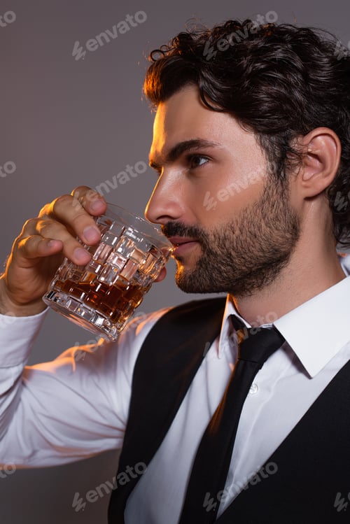 Preview: brunette man in white shirt and black tie drinking whiskey isolated on grey