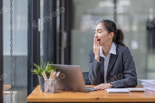 Preview: Portrait of tired young business Asian woman work with documents tax laptop computer in office. Sad,
