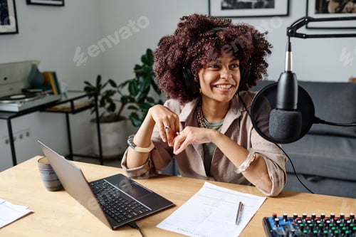 Preview: Young cheerful woman with headphones speaking in microphone