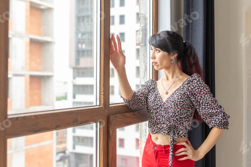 Preview: Daydreaming, thoughtfulness and loneliness - Woman looking out through window