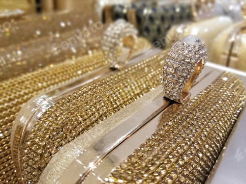 Preview: Sparkly clutch purses lined up on display in a store.