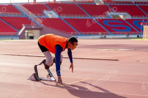 Preview: Asian para-athletes with prosthetic blades sprint on a running track at stadium.