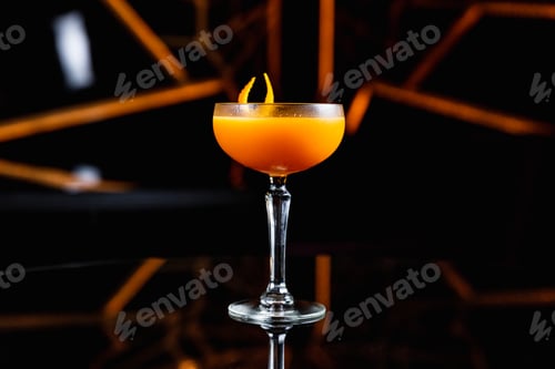 Vista previa: Cóctel de naranja y cítricos en una copa cupé, adornado con piel de naranja sobre una mesa negra con reflejos