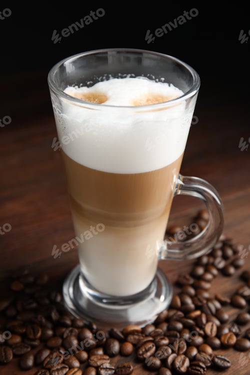 Preview: Delicious latte macchiato and coffee beans on wooden table