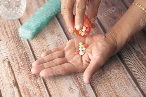 Preview: senior women hand's taking medicine, close up