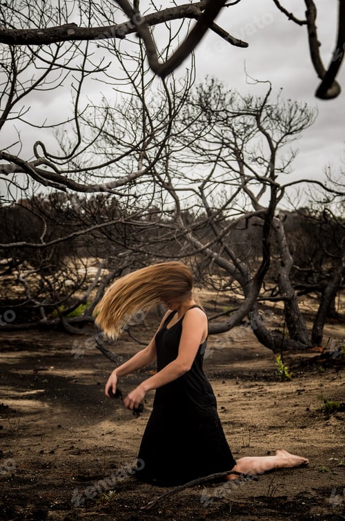 Preview: Woman posing on ground near dry trees
