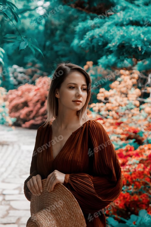 Preview: style woman near rhododendron flowers in a grarden