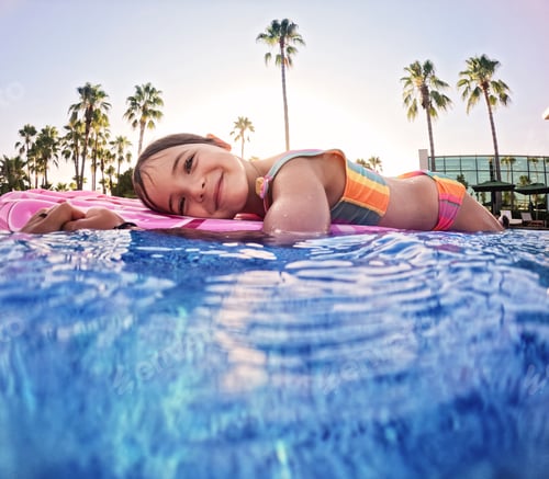 Preview: Girl floats on pink inflatable in the pool. Beach resort vacation by the sea. Winter and summer
