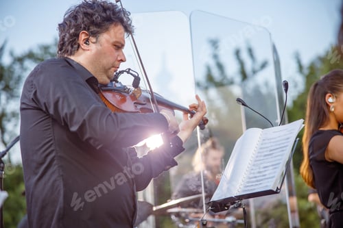 Preview: Male violinist playing in orchestra on the street