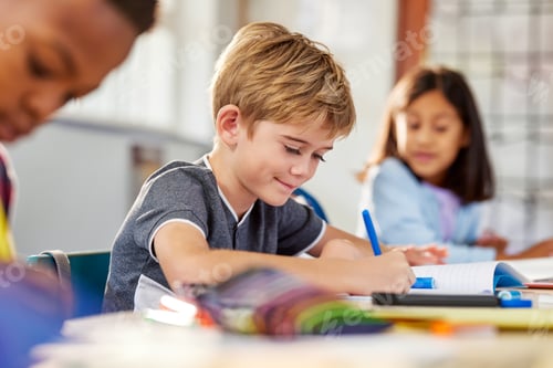 Visualização: Menino do ensino fundamental escrevendo no caderno na escola