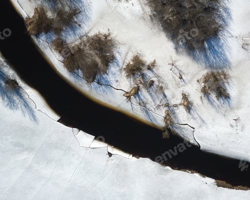 Preview: River in a swamp during wintertime, ice and snow all around, drone photography