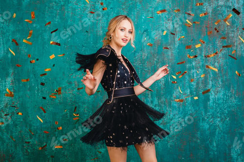 Preview: woman in party dress celebrating new year with golden confetti