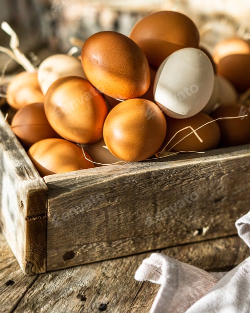 Preview: Fresh raw eggs in wooden box crate over wooden brown rustic background