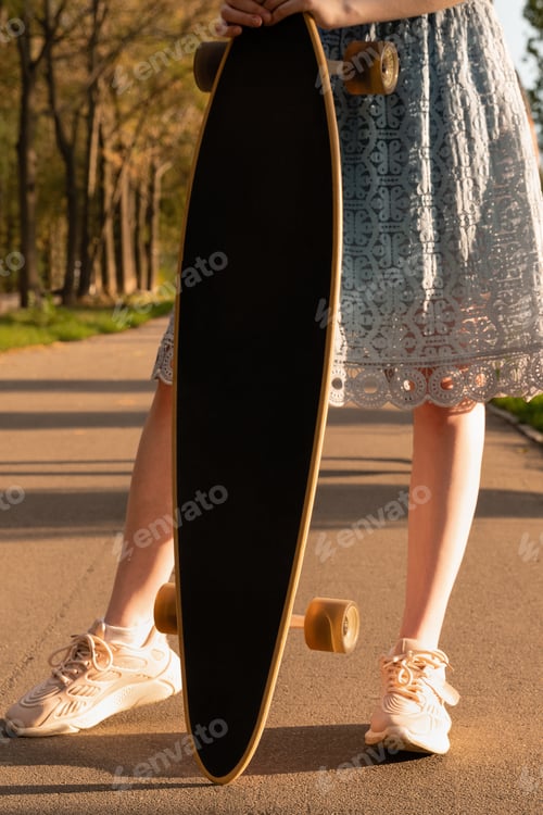 Preview: Crop unrecognizable woman holding longboard during summer vacation