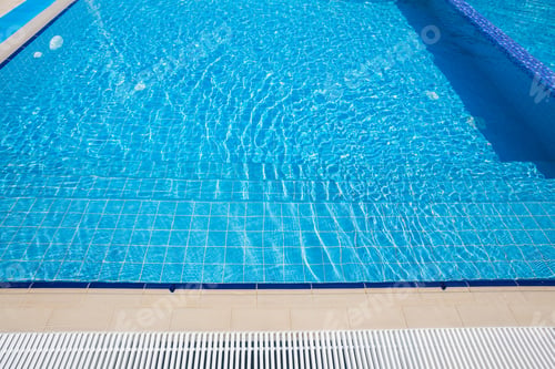 Preview: Clear blue swimming pool under bright sunlight inviting relaxation and recreation in a peaceful