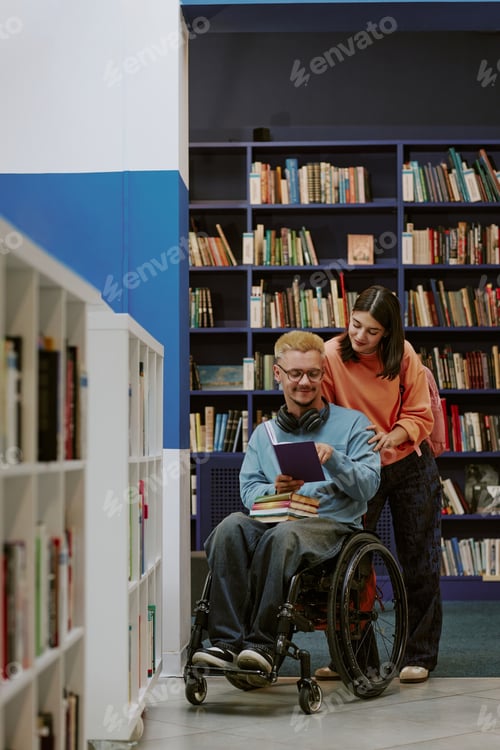 Preview: Smiling Man in Wheelchair Holding Tablet in Library Setting