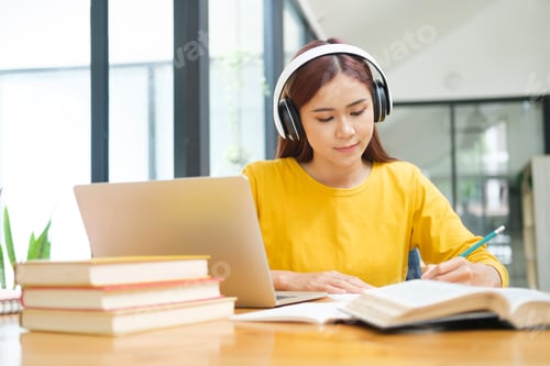 Preview: Young collage student using computer and mobile device studying online.