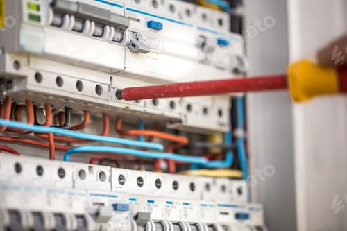 Preview: Man, an electrical technician working in a switchboard with fuses.