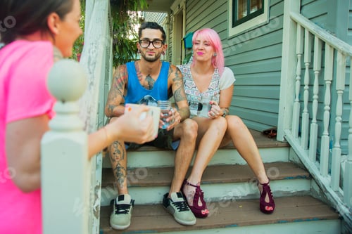 Preview: Young adult friends chatting on porch steps