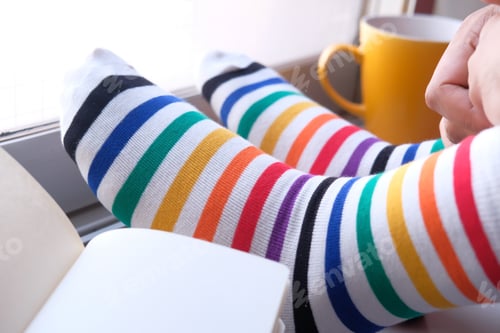 Preview: Feet in woolen socks with tea on floor.