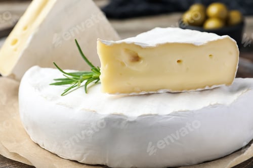 Preview: Tasty cut brie cheese with rosemary on parchment