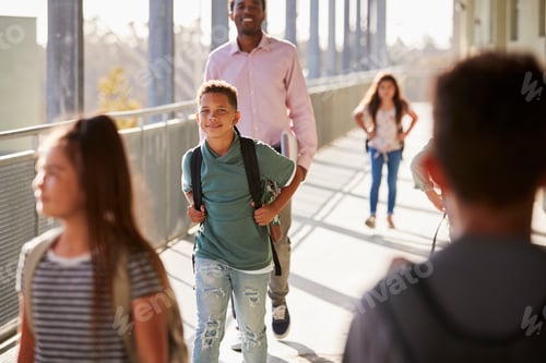 Preview: Male teacher and pupils walking in school campus