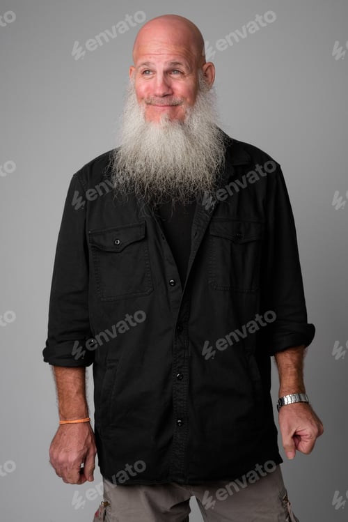 Preview: Happy mature handsome bald man with long beard thinking