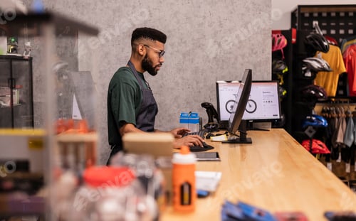 Preview: Bicycle shop owner working at point of sale computer