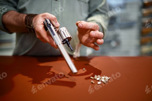 Preview: Man reload revolver at the counter in gun store