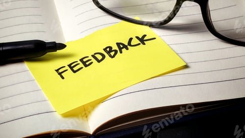 Preview: Importance of Constructive Feedback: Yellow Reminder Note on Open Notebook