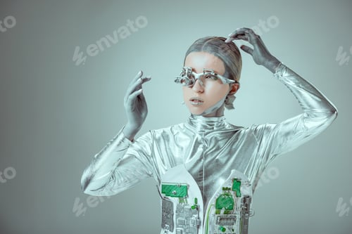 Preview: young woman robot touching head and looking away isolated on grey, future technology concept