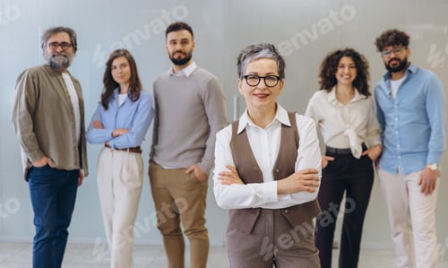 Preview: Mature business leader woman with diverse professional team smiling