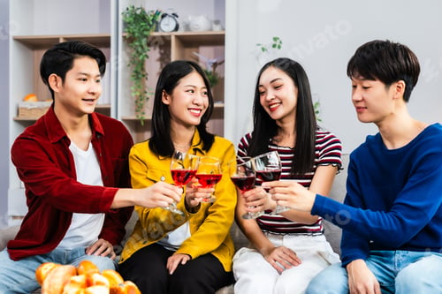Preview: Young Asian friends gather living room, cheering celebrating watching a soccer match on TV.