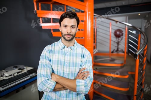 Preview: Professional audio mixing console glowing beside orange spiral stairs and industrial fan in studio