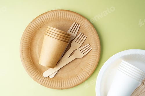 Preview: Scattered eco-friendly paper cups and forks on green background