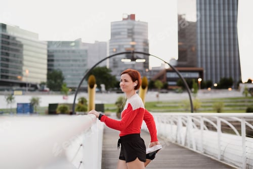 Preview: Young woman doing exercise on bridge outdoors in city, stretching