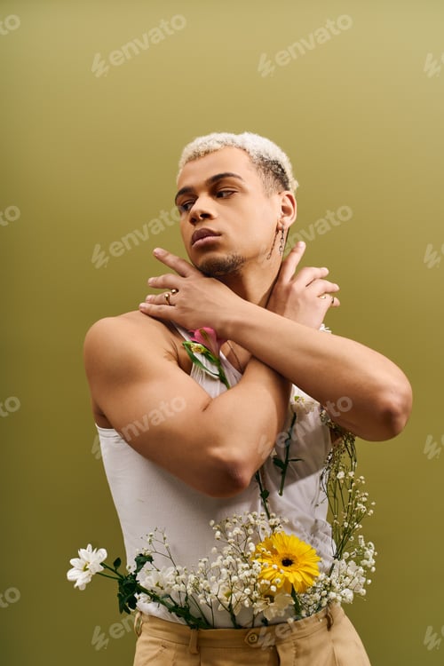 Preview: Young man showcases unique style with flowers in vibrant studio setting