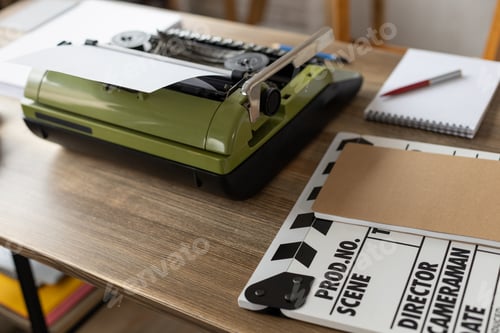 Preview: Clapper board and vintage typewriter at wooden desk table