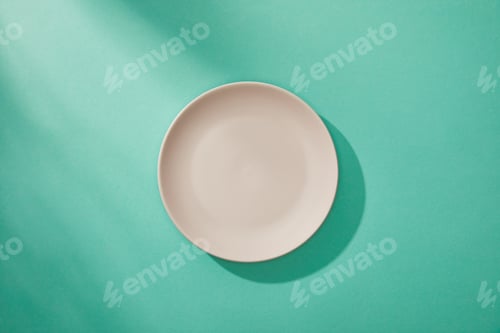 Preview: Top view of empty plate on turquoise background
