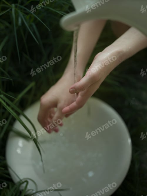 Preview: Young woman washing hands under flowing water, close-up