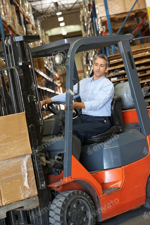 Preview: Man Driving Fork Lift Truck In Warehouse