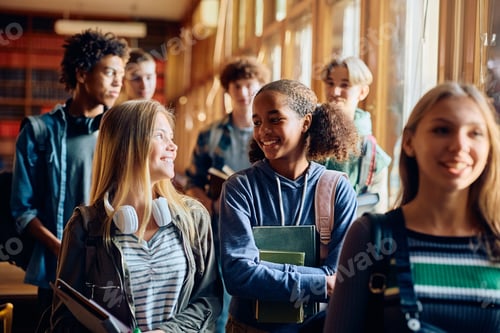 Preview: Multiracial group of happy high school students talking after the class.