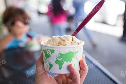 Preview: Closeup of a person hand holding ice cream in a park