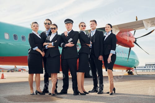 Preview: Posing for a camera. Crew of airport and plane workers in formal clothes standing outdoors together